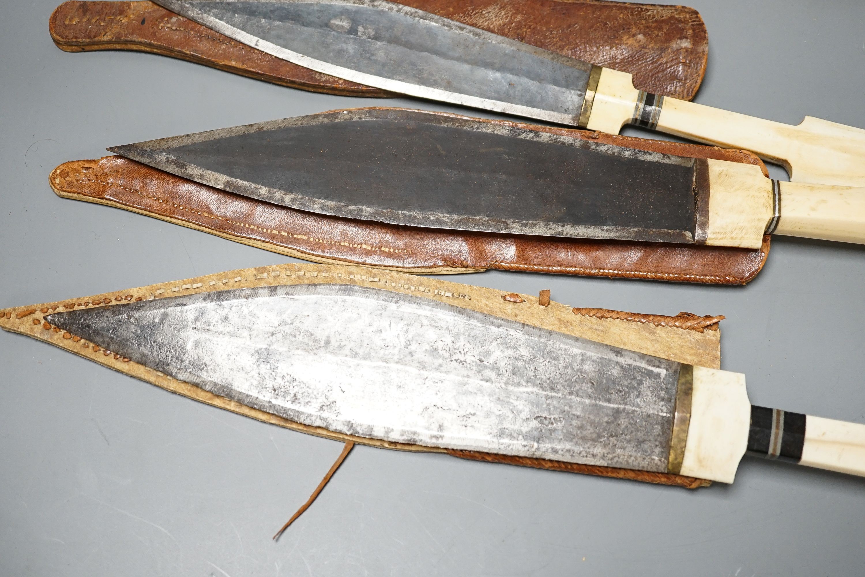 Four similar African tribal daggers c.1900, each with hippo tusk handle including two with silver pommels, all in their decorated leather scabbards with 1 belt, maximum 45cms.